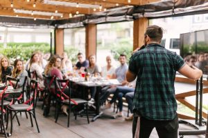 Man stands and speaks in front of group of individuals