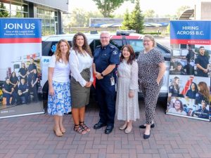 A group of five BCEHS employees stand together, smiling